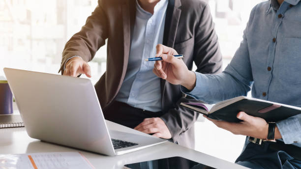 Asian business adviser meeting to analyze and discuss the situation on the financial report in the meeting room. Financial advisor and accounting concept